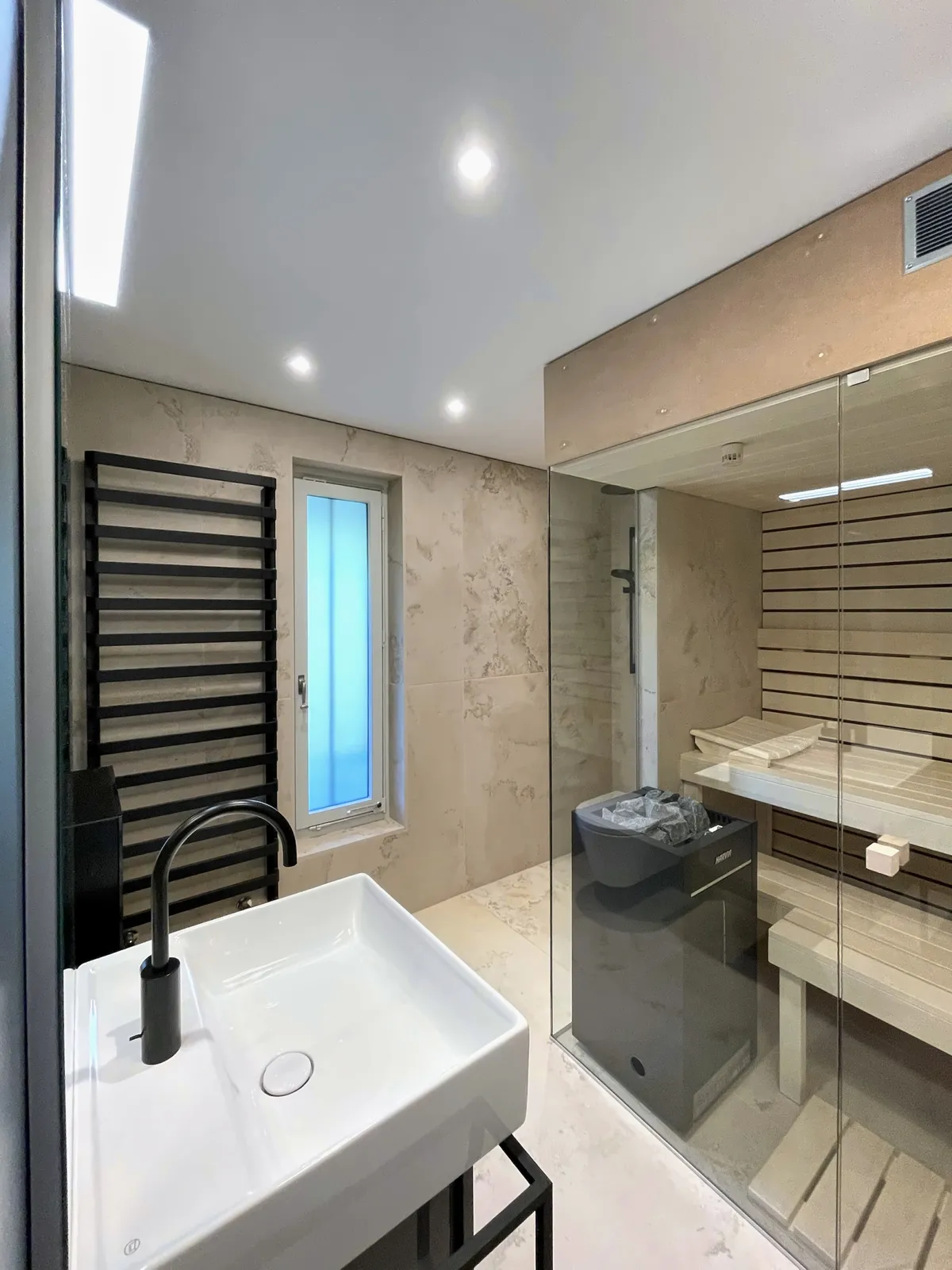 Sauna, Handtuchradiator und schmales Fenster in der Keramikwand