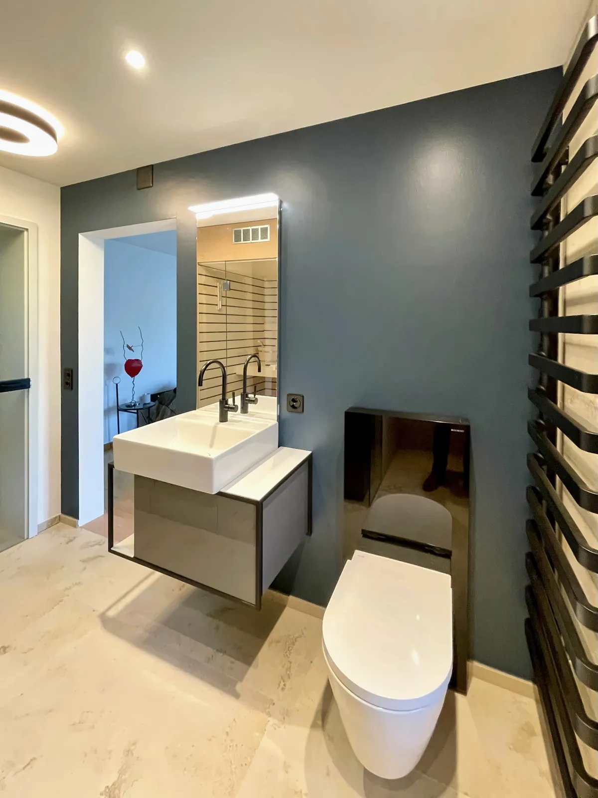 Waschplatz und WC vor der Wand in Petrol, Durchblick ins Schlafzimmer